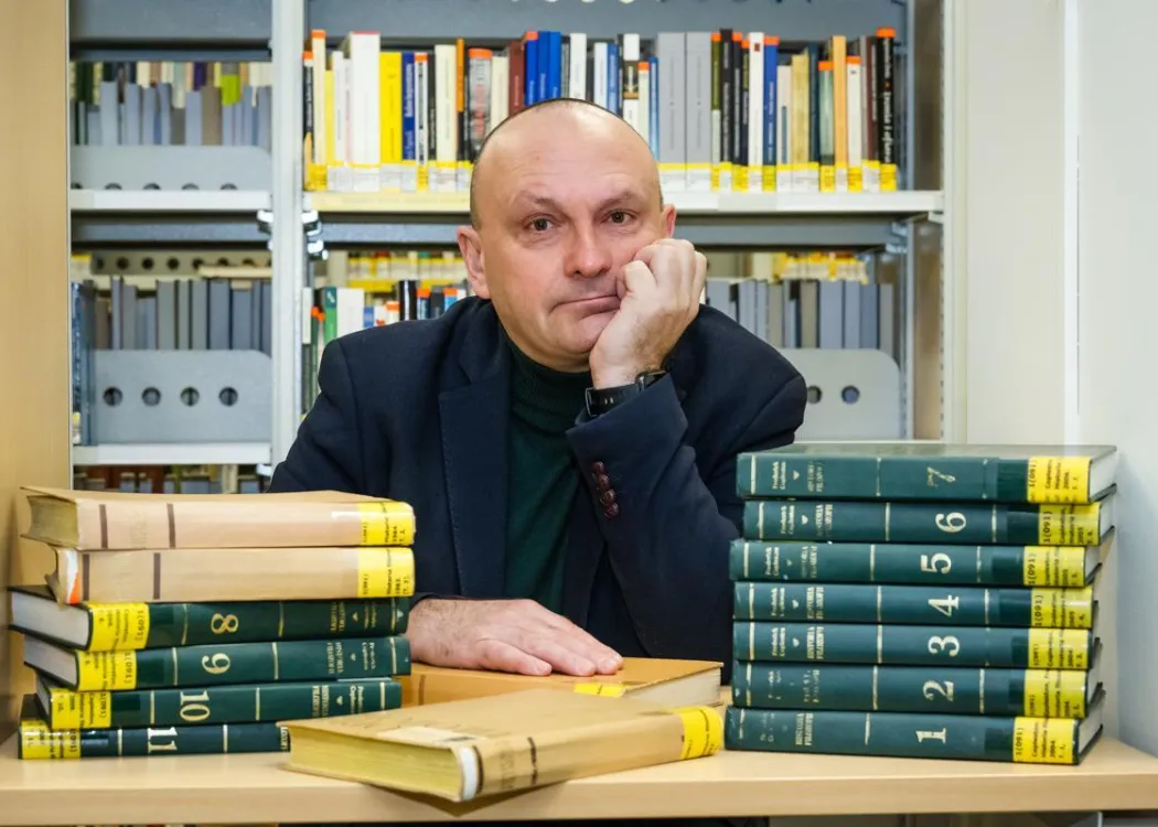 Mirosław Pawliszyn siedzi przed książkami 
