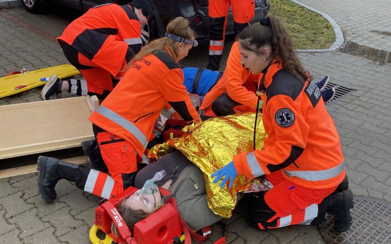 ratownicy udzielają pierwszej pomocy poszkodowanemu na ulicy