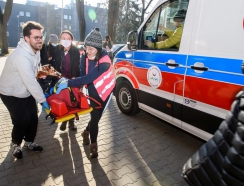 studenci na noszach wiozą rannego do ambulansu